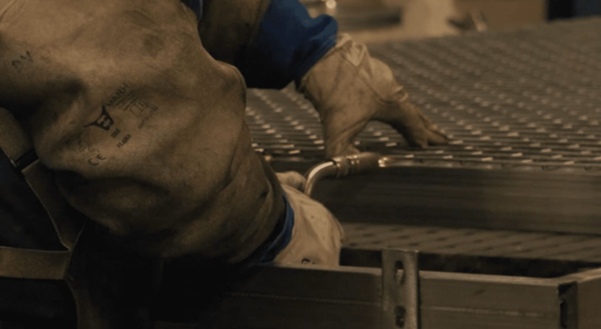Technician welding steel mesh panels during the Padel Tech manufacturing process.